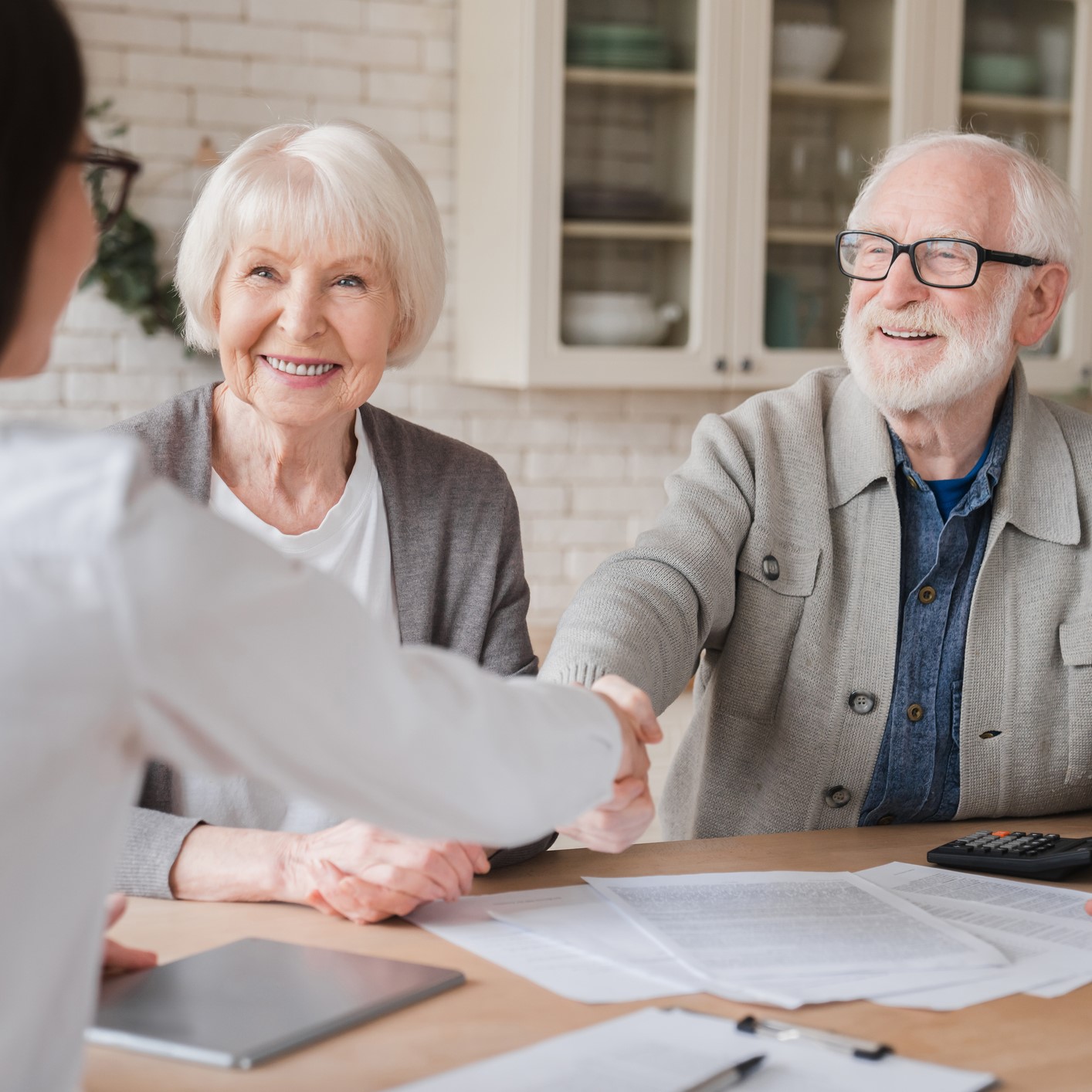 Older man and woman meeting with an audiologist at home.