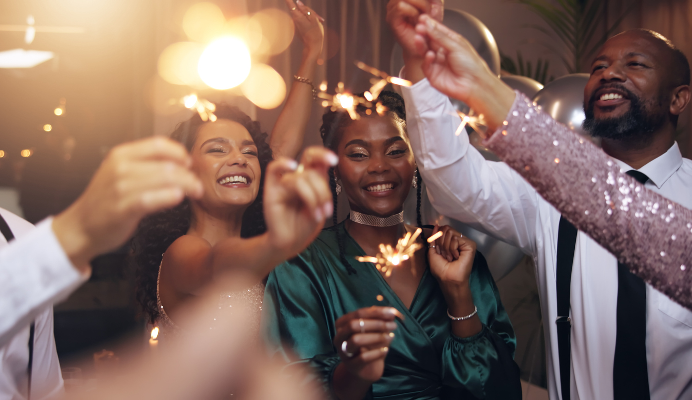 Group of happy friends holding sparklers at a holiday party